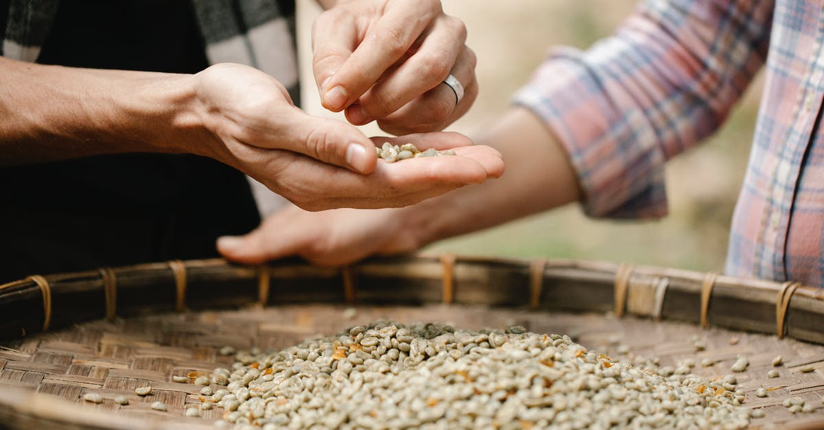 Is there some sort of pot with a sort of sieve on the bottom to separate sauce? - Crop unrecognizable horticulturists separating raw coffee beans from chaff over bamboo tray while working in countryside Is there some sort of pot with a sort of sieve on the bottom to separate sauce? - Crop unrecognizable horticulturists separating raw coffee beans from chaff over bamboo tray while working in countryside