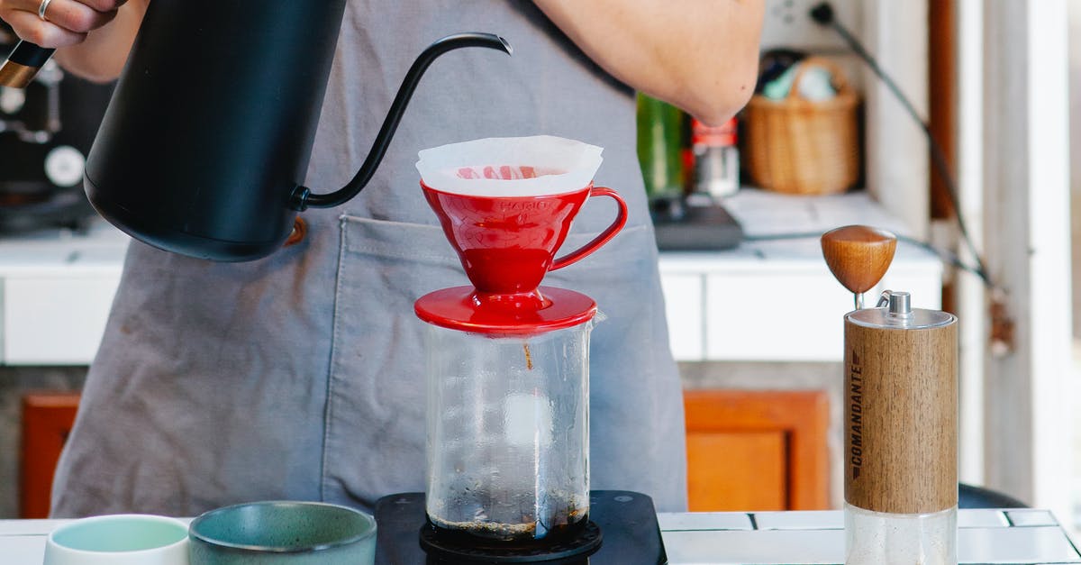 Is this coffee maker safe to use? - Crop anonymous female barista in apron preparing coffee using pour over coffee maker and drip kettle in light cafe