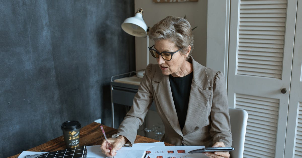 Is this coffee ratio calculation correct? - From above of concentrated senior female manager in formal outfit and eyeglasses taking notes in planner while working at table with various documents and takeaway coffee in cozy office Is this coffee ratio calculation correct? - From above of concentrated senior female manager in formal outfit and eyeglasses taking notes in planner while working at table with various documents and takeaway coffee in cozy office