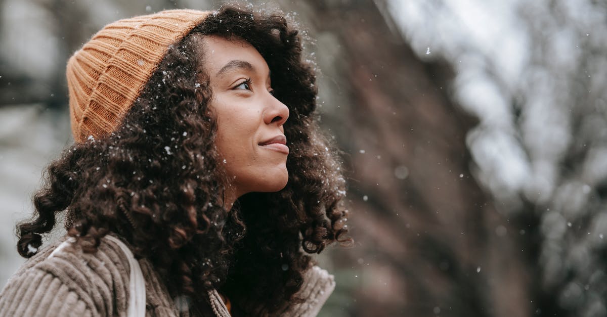 Is this some kind of warming oven? - Side view of dreamy young black female in knitted hat looking up in town on snowy day Is this some kind of warming oven? - Side view of dreamy young black female in knitted hat looking up in town on snowy day