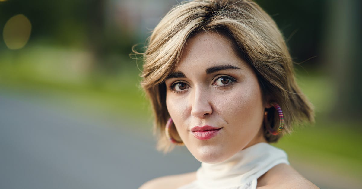 Is this the way to make good pies? - Headshot of attractive female wearing white outfit and earrings standing near asphalt road and grassy lawn on blurred background in city with bokeh Is this the way to make good pies? - Headshot of attractive female wearing white outfit and earrings standing near asphalt road and grassy lawn on blurred background in city with bokeh