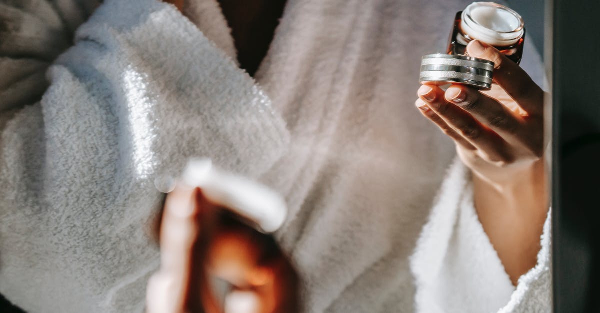 Isi cream whipper head valve sticks open - Crop ethnic woman with jar of cream against mirror Isi cream whipper head valve sticks open - Crop ethnic woman with jar of cream against mirror