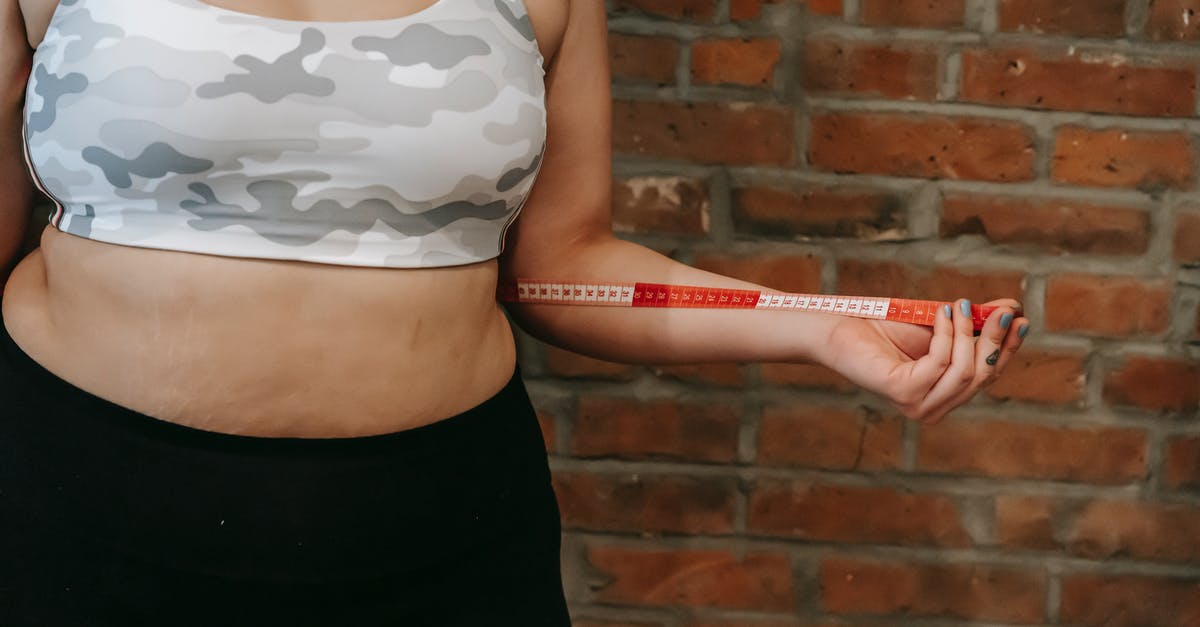 Isn't moisture a problem when measuring flour by weight? - Crop anonymous plump female using measuring tape for measuring belly near brick wall Isn't moisture a problem when measuring flour by weight? - Crop anonymous plump female using measuring tape for measuring belly near brick wall