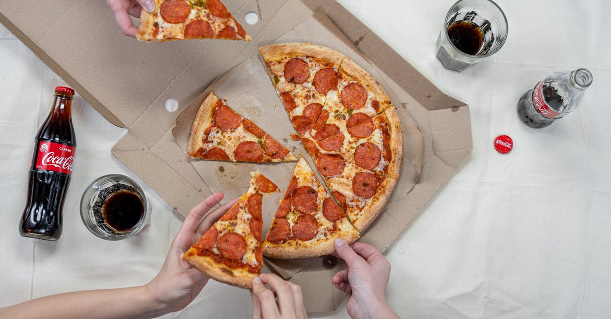 Israeli soda type drink - Person Holding Pizza on White Box Israeli soda type drink - Person Holding Pizza on White Box