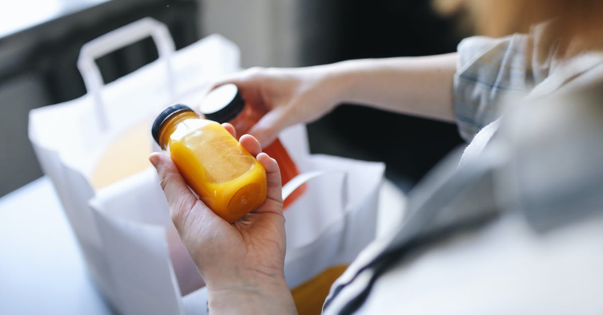 Juicing nectarines - Person Holding Orange Plastic Bottle