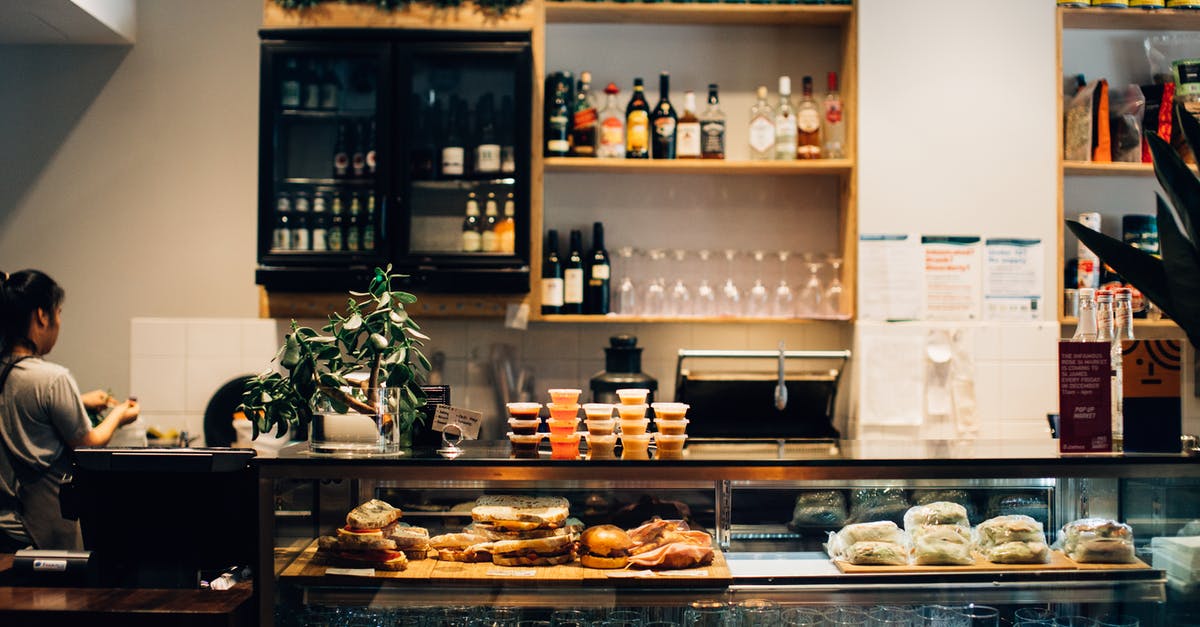 keep house hold chemicals bottles near food shelves - Counter with Sandwiches in Front of Shelves with Bottles in a Café keep house hold chemicals bottles near food shelves - Counter with Sandwiches in Front of Shelves with Bottles in a Café
