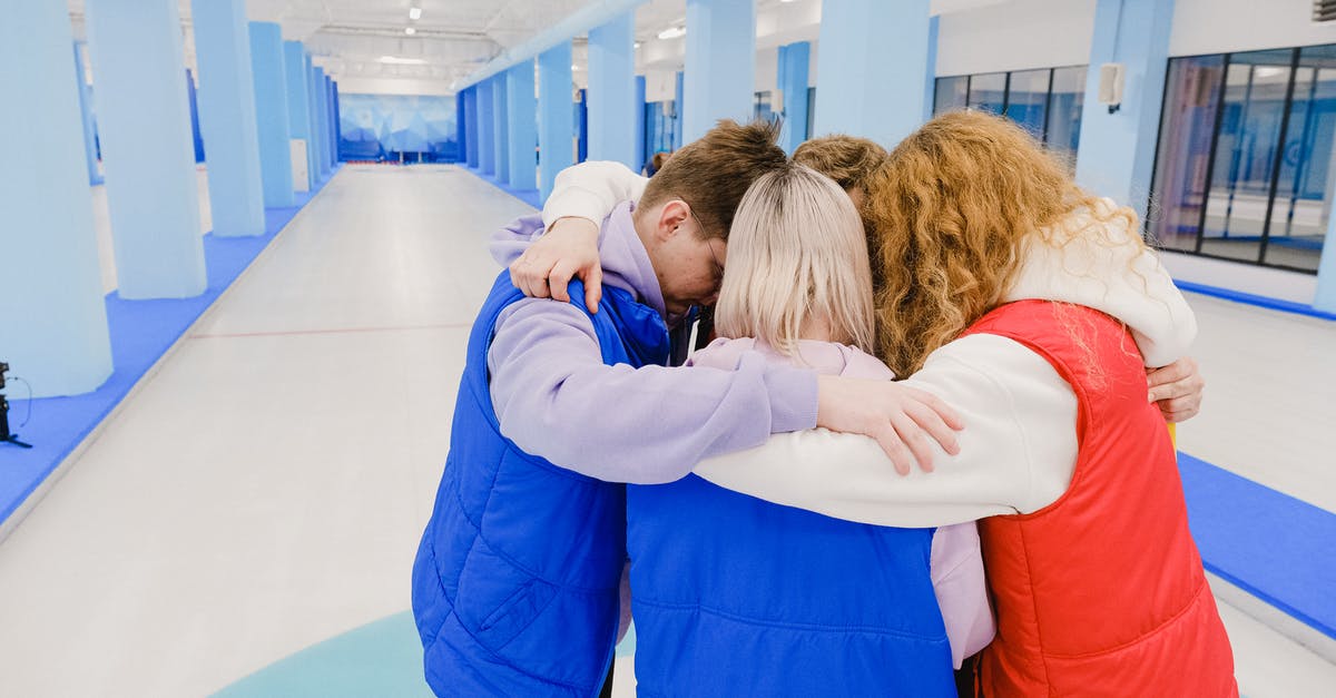 Keeping crushed ice from melting, without it joining back together - High angle of anonymous team embracing each other while standing in spacious light gym Keeping crushed ice from melting, without it joining back together - High angle of anonymous team embracing each other while standing in spacious light gym