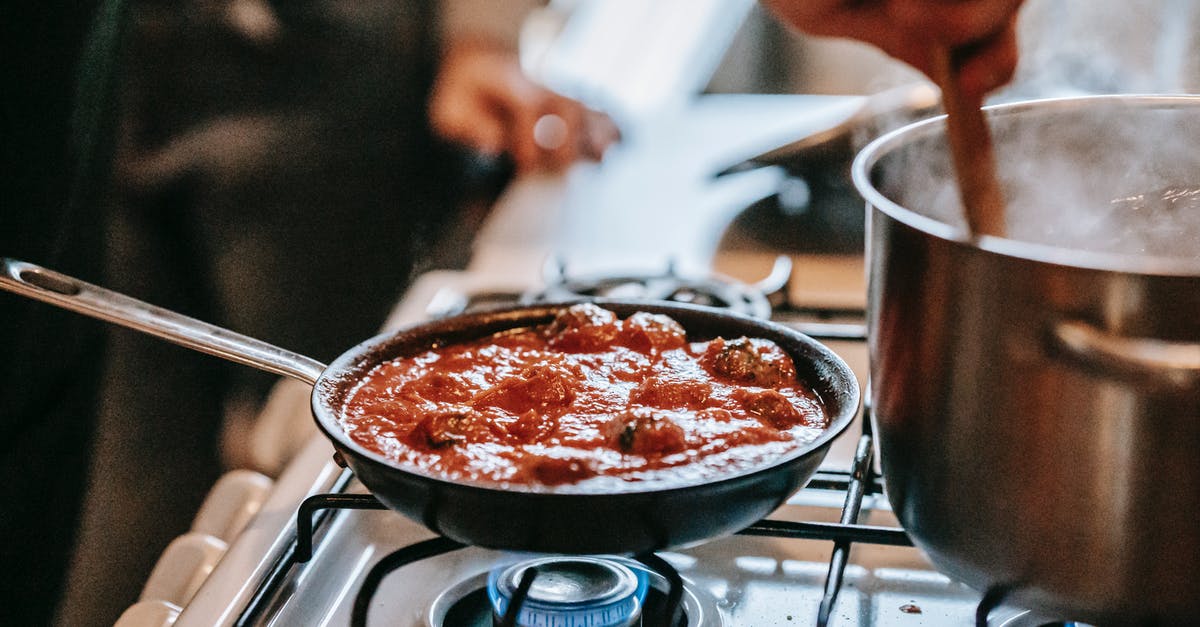 Keeping left-over pan sauces longer? - Crop unrecognizable person stirring boiling water in saucepan placed on gas stove near frying pan with appetizing meatballs in tomato sauce Keeping left-over pan sauces longer? - Crop unrecognizable person stirring boiling water in saucepan placed on gas stove near frying pan with appetizing meatballs in tomato sauce
