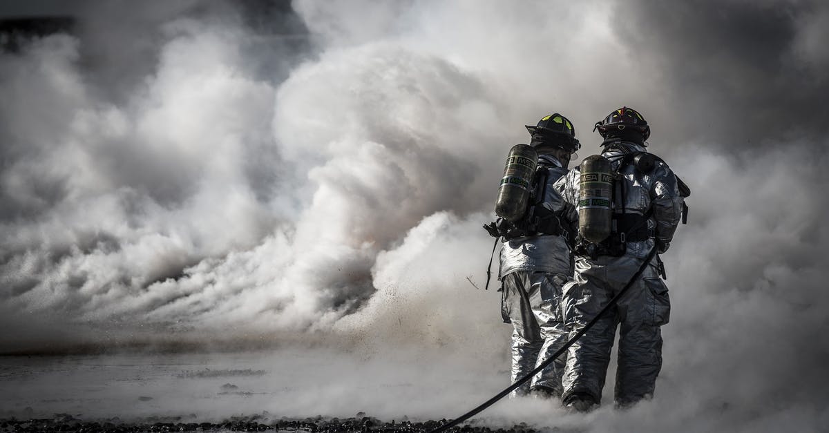 Keeping oil spray nozzle from clogging - Firefighter Standing Beside Smoke Keeping oil spray nozzle from clogging - Firefighter Standing Beside Smoke