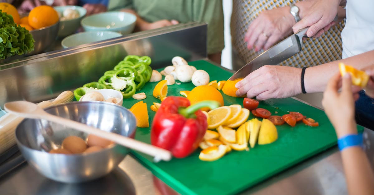 Knife chopping through bone or coconut - Person Chopping Orange on Green Chopping Board
