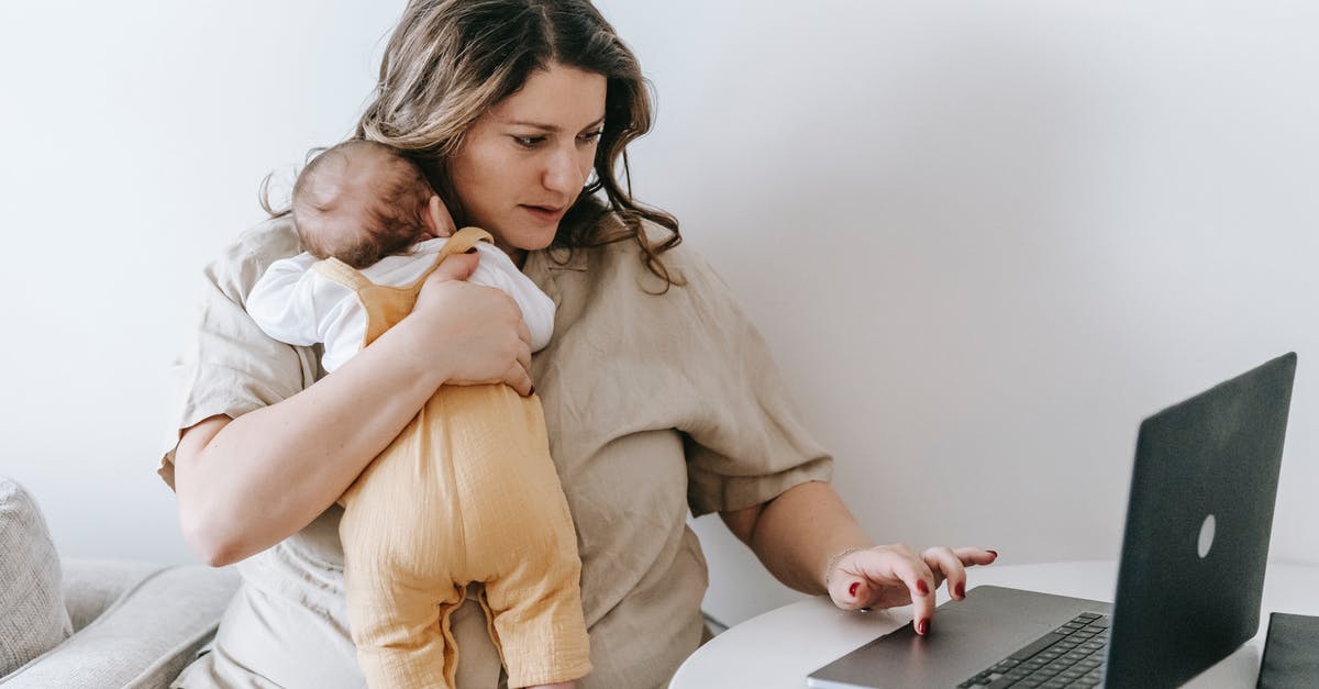 Lentils and barley used together - Concentrated young female freelancer embracing newborn while sitting at table and working remotely on laptop at home Lentils and barley used together - Concentrated young female freelancer embracing newborn while sitting at table and working remotely on laptop at home
