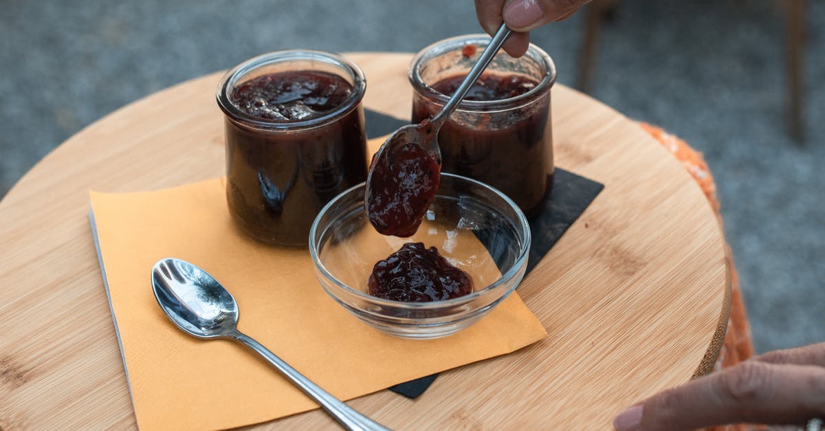 licking spoon and putting back in the food - A Person Putting Jam in a Glass Bowl