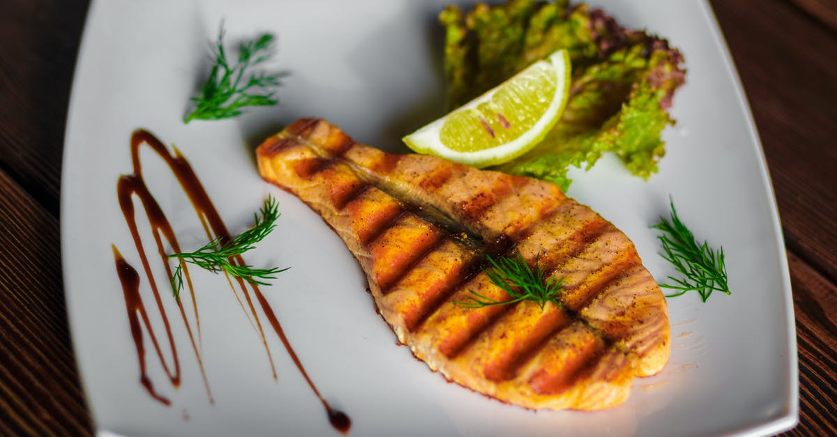 Lime on Fish tastes Bitter - A Slice of Grilled Fish and Lime on a Square Ceramic Plate Lime on Fish tastes Bitter - A Slice of Grilled Fish and Lime on a Square Ceramic Plate