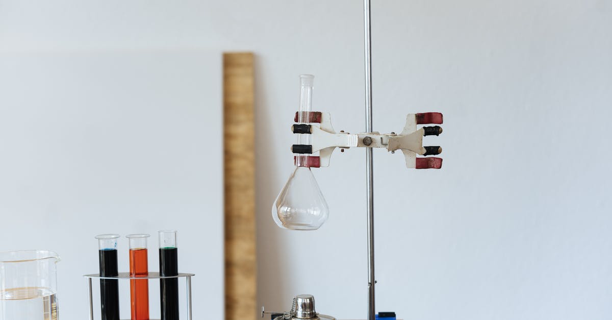 Liquid glucose stuck furniture - Chemical test with empty flask mounted on ring stand while burner under flask and tubes filled with reagents in modern lab Liquid glucose stuck furniture - Chemical test with empty flask mounted on ring stand while burner under flask and tubes filled with reagents in modern lab