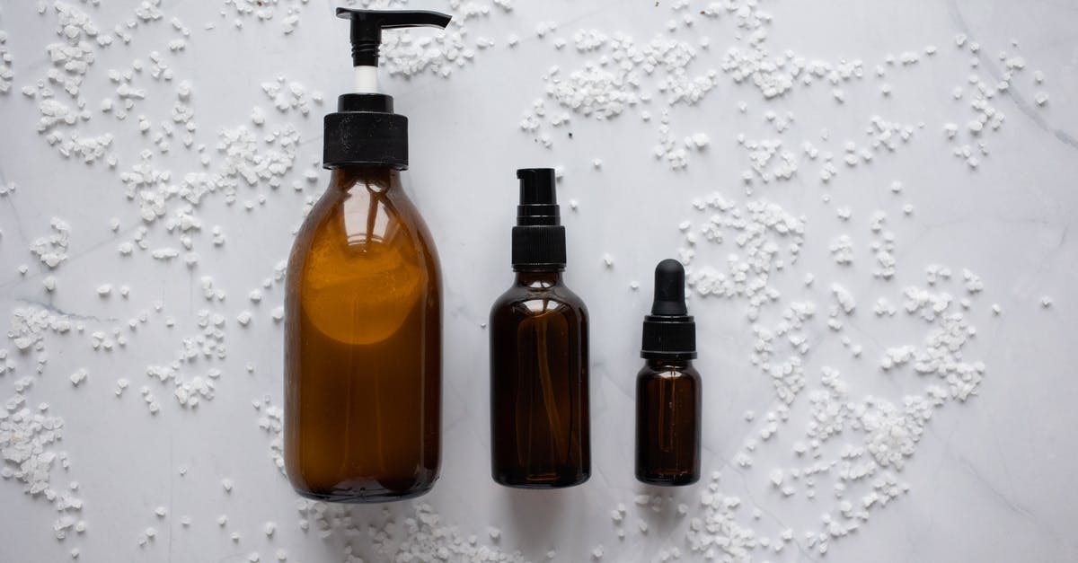Liquid Pockets in Cream Cheese - Bottles of cosmetic products placed on white surface Liquid Pockets in Cream Cheese - Bottles of cosmetic products placed on white surface