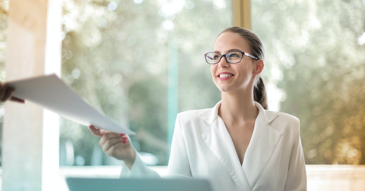 looking for edible paper - Low angle of successful female executive manager in classy style sitting at table with laptop in contemporary workplace and passing documents to colleague looking for edible paper - Low angle of successful female executive manager in classy style sitting at table with laptop in contemporary workplace and passing documents to colleague