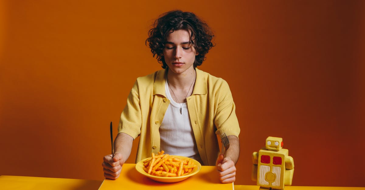 Looking for the name of an orange crunchy snack - Young Man Looking Down On A Plate Of Fries Looking for the name of an orange crunchy snack - Young Man Looking Down On A Plate Of Fries