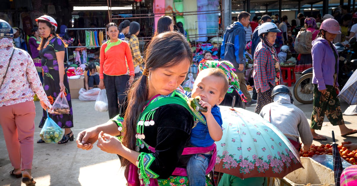 Make quinoa sticky like rice? - Young Asian mom with toddler child eating tasty sweet rice in banana leaf against anonymous shoppers in urban bazaar Make quinoa sticky like rice? - Young Asian mom with toddler child eating tasty sweet rice in banana leaf against anonymous shoppers in urban bazaar