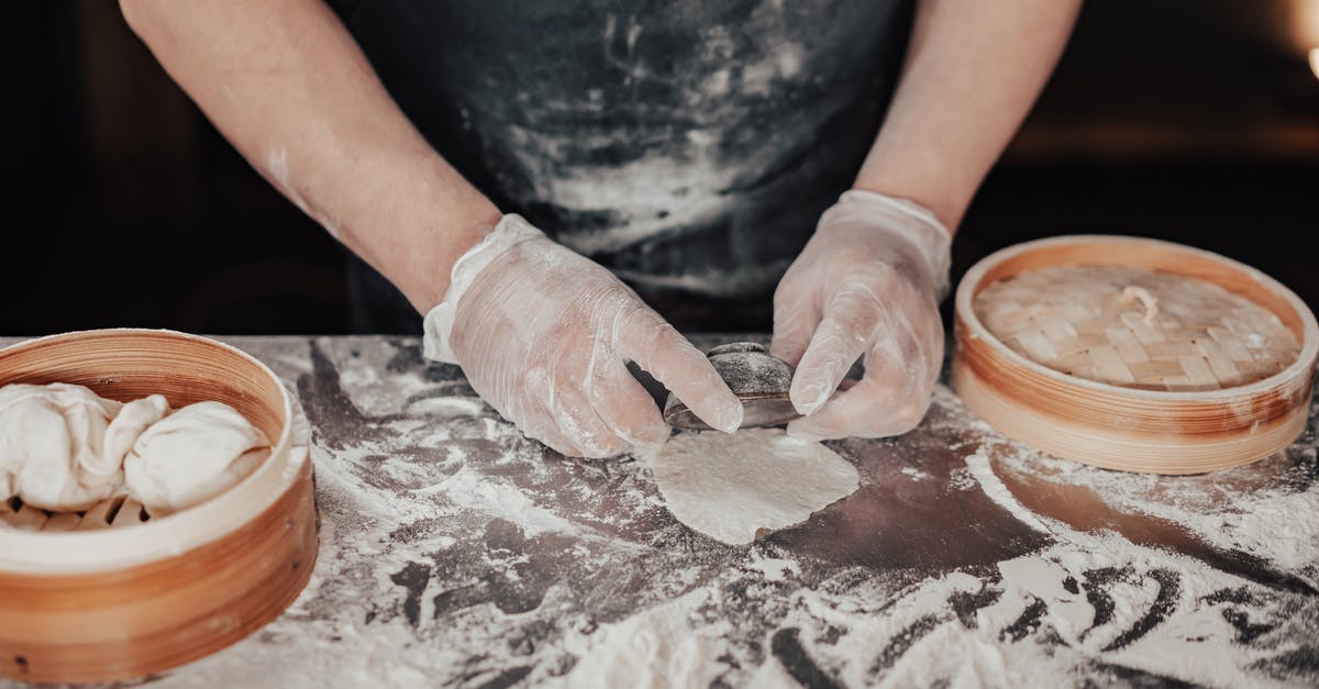 Making doughballs (dumplings) with strong brown flour and shredded suet - A Person Making a Dumpling while Wearing Gloves Making doughballs (dumplings) with strong brown flour and shredded suet - A Person Making a Dumpling while Wearing Gloves
