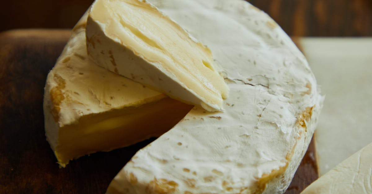 Making hard cheese from milk by vinegar - Sliced Cheese on Brown Wooden Table Making hard cheese from milk by vinegar - Sliced Cheese on Brown Wooden Table