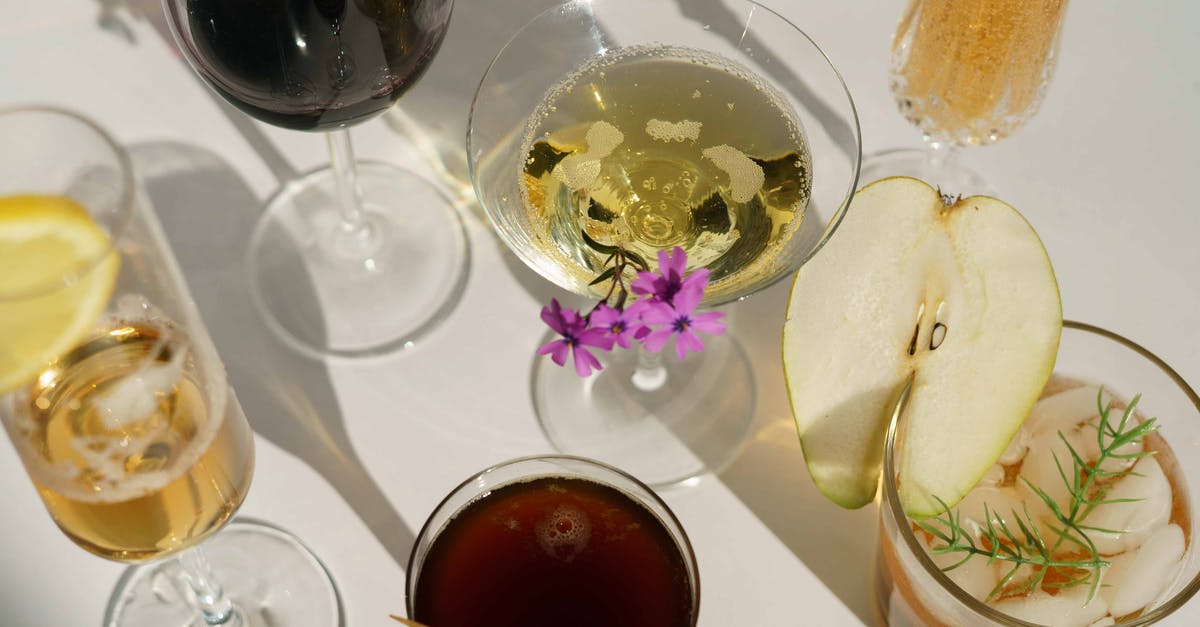Making lemon oil from vodka - Glasses of cocktails decorated with pear and blooming flowers Making lemon oil from vodka - Glasses of cocktails decorated with pear and blooming flowers