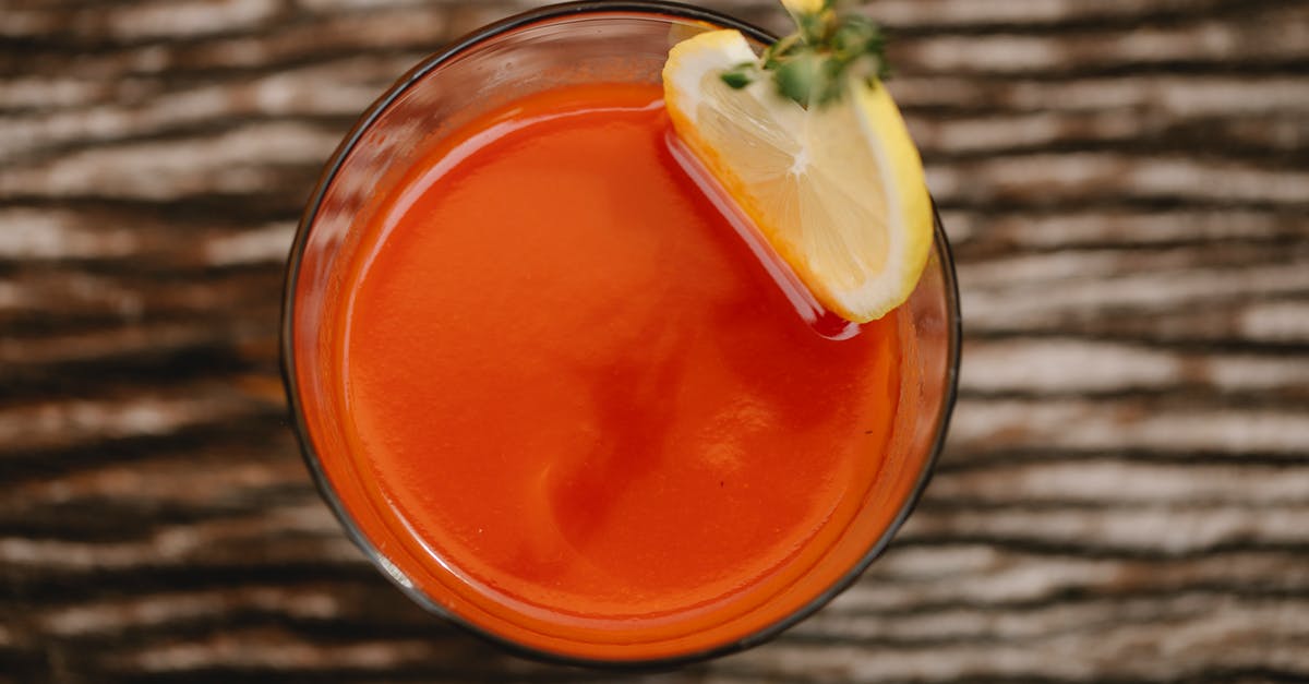 Making lemon oil from vodka - From above of colorful tasty alcoholic drink with tomato juice and thyme sprig on top of glass Making lemon oil from vodka - From above of colorful tasty alcoholic drink with tomato juice and thyme sprig on top of glass