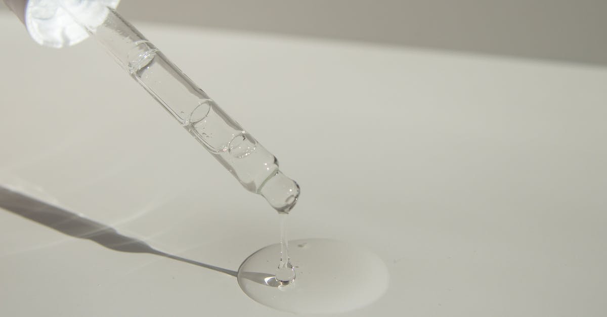 Making licorice root syrup or extract - Anonymous person pouring liquid product on table with pipette Making licorice root syrup or extract - Anonymous person pouring liquid product on table with pipette