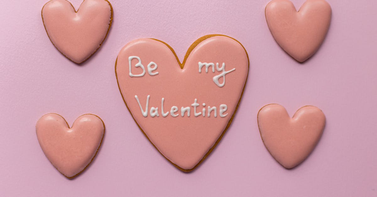 Making my meringues form peaks - Top view of sweet heart shaped cookies saying Be My Valentine on pink background Making my meringues form peaks - Top view of sweet heart shaped cookies saying Be My Valentine on pink background