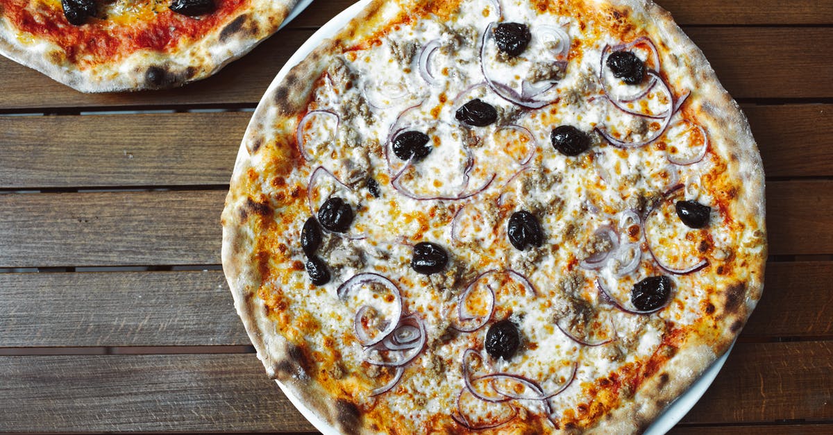 Making pizza toppings stay intact without using cheese - A Whole Pizza on a Wooden Table Making pizza toppings stay intact without using cheese - A Whole Pizza on a Wooden Table