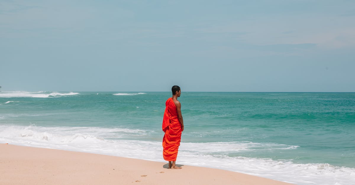 Making sourdough bread in a warm and humid climate - Unrecognizable Asian man in traditional orange cloth on beach Making sourdough bread in a warm and humid climate - Unrecognizable Asian man in traditional orange cloth on beach