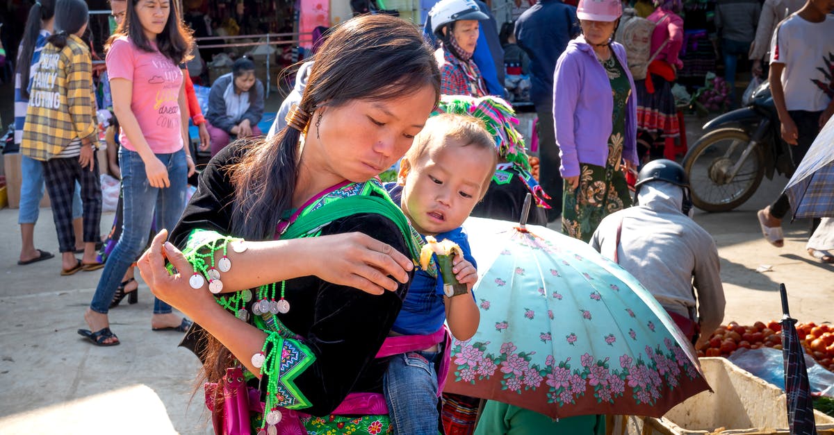 Making sticky rice without rice cooker - Asian mom carrying baby with sweet rice treat in market Making sticky rice without rice cooker - Asian mom carrying baby with sweet rice treat in market