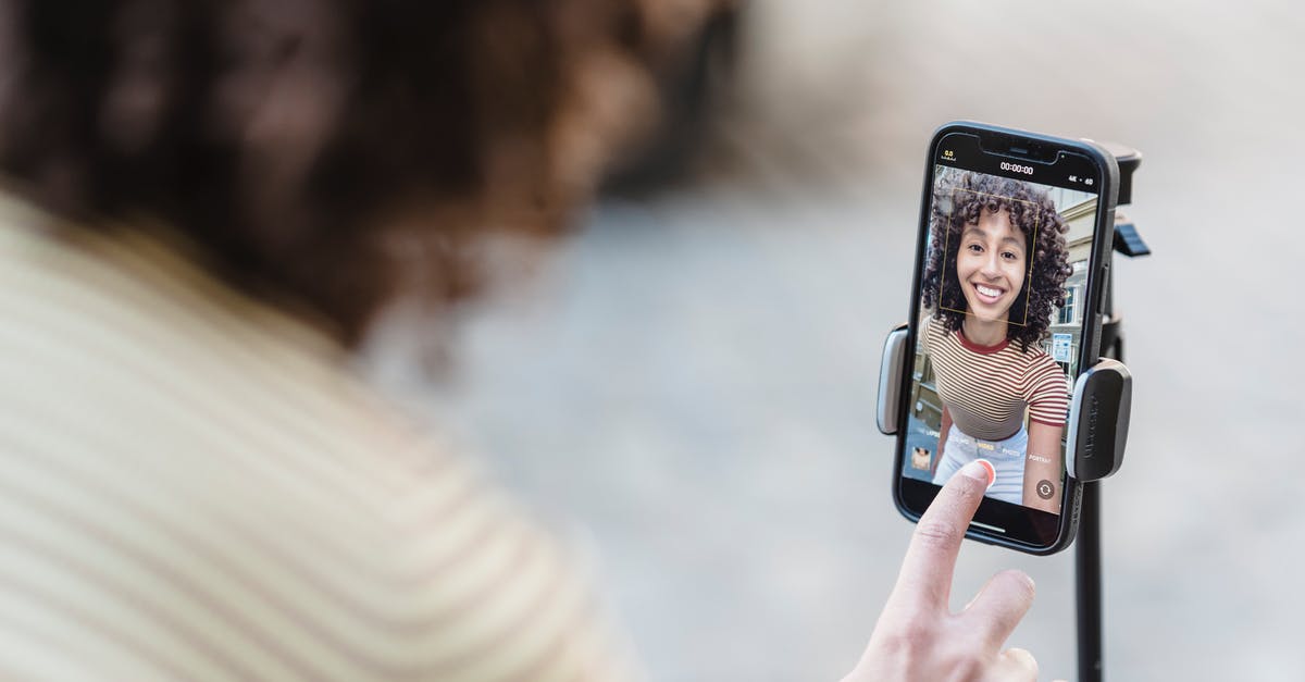 Marinade tenderizing process - Crop cheerful young ethnic female vlogger touching screen on cellphone while preparing for video record in town Marinade tenderizing process - Crop cheerful young ethnic female vlogger touching screen on cellphone while preparing for video record in town