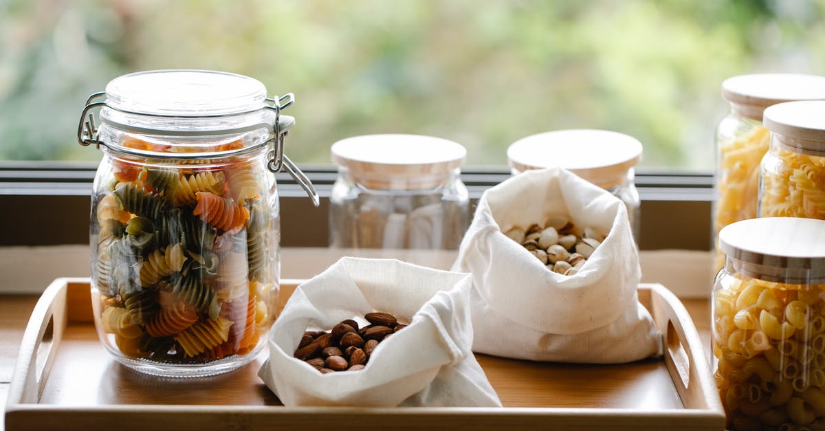 Mascarpone and Almond pasta Sauce? - Glass jar with rotini pasta placed on wooden tray near ECO friendly bags with almonds and pistachios in light room near window on blurred background Mascarpone and Almond pasta Sauce? - Glass jar with rotini pasta placed on wooden tray near ECO friendly bags with almonds and pistachios in light room near window on blurred background