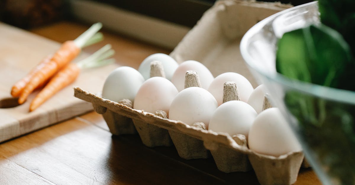 Meals to cook using a whole chicken - Carton box with white organic eggs placed on kitchen counter near chopping board with carrots Meals to cook using a whole chicken - Carton box with white organic eggs placed on kitchen counter near chopping board with carrots
