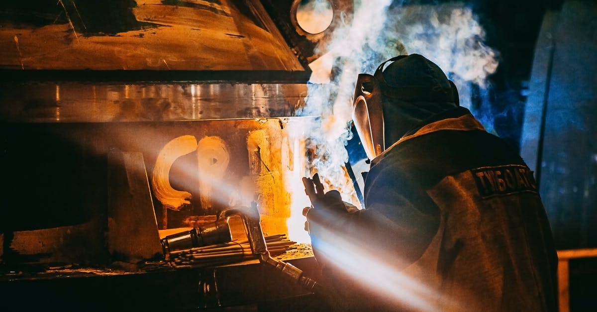 Melting sugar on creme brulee with blow torch - Person Wearing Gray Jacket and Welding Helmet Melting sugar on creme brulee with blow torch - Person Wearing Gray Jacket and Welding Helmet