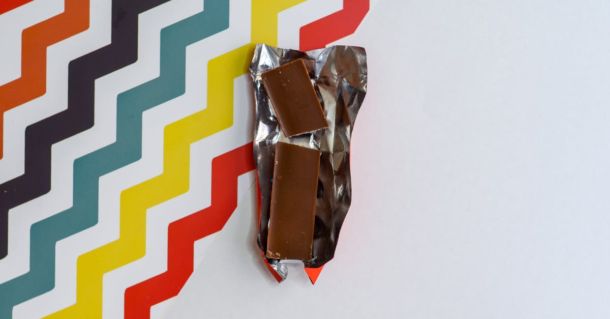 Metalic Foil on Indian Sweets - Brown Chocolate Bar on Multicolored Surface Metalic Foil on Indian Sweets - Brown Chocolate Bar on Multicolored Surface