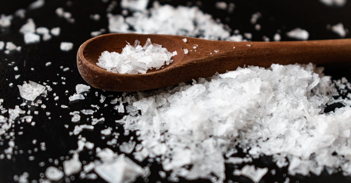 Methods for seasoning wooden spoons? - Closeup of wooden spoon arranged with sea salt scattered on table in kitchen Methods for seasoning wooden spoons? - Closeup of wooden spoon arranged with sea salt scattered on table in kitchen