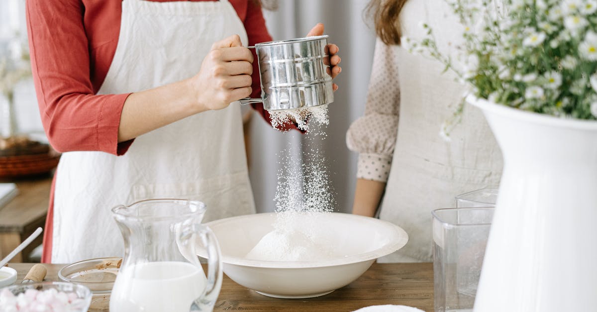 Milk powder doesn't dissolve - Woman Wearing an Apron Holding a Sifter Milk powder doesn't dissolve - Woman Wearing an Apron Holding a Sifter