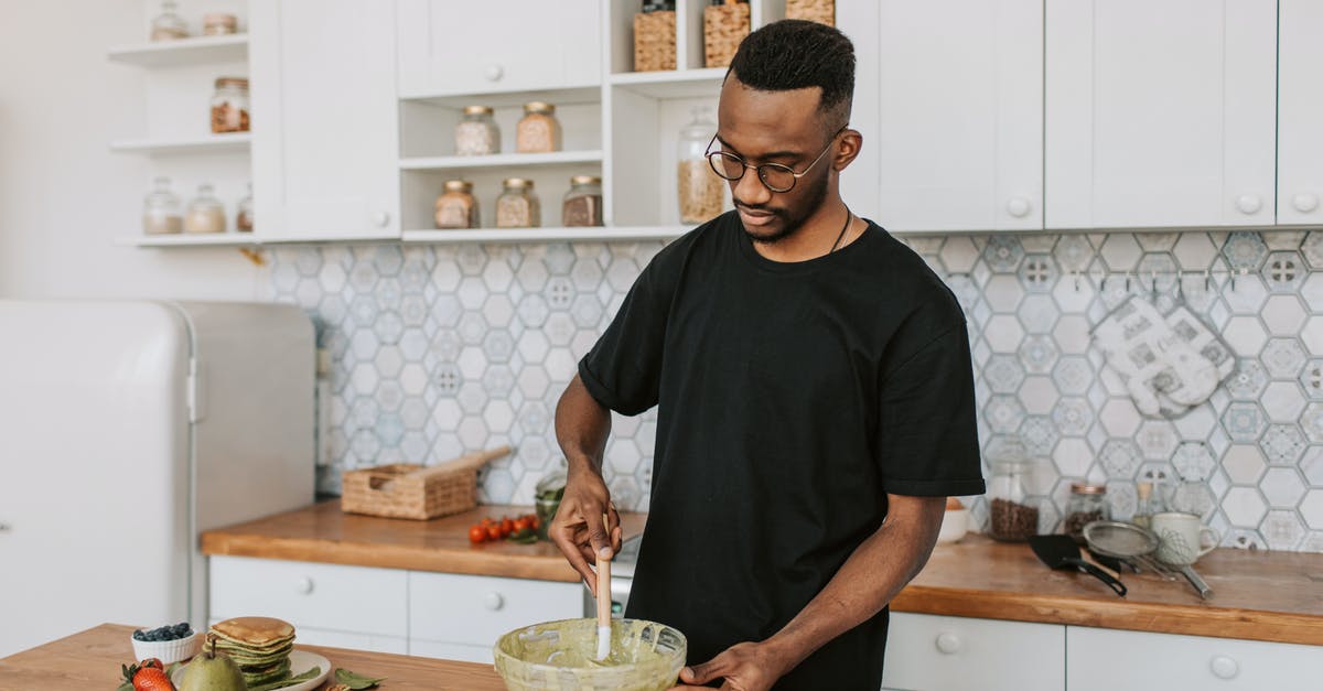 Mixing cheesecake batter with an immersion blender - A Man Mixing Batter in a Bowl Mixing cheesecake batter with an immersion blender - A Man Mixing Batter in a Bowl