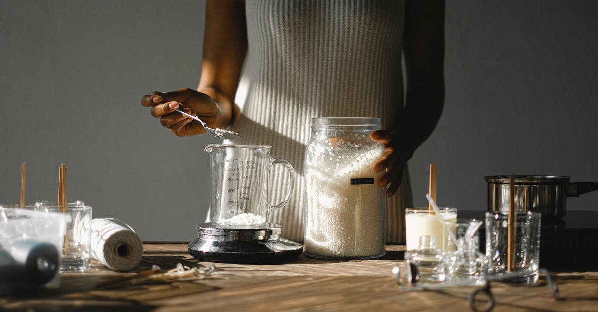 Mold on homemade sriracha - Crop black woman pouring wax into beaker Mold on homemade sriracha - Crop black woman pouring wax into beaker