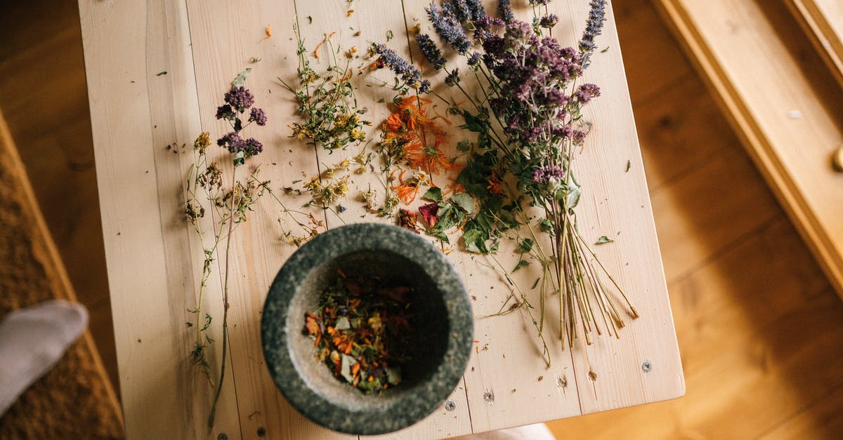 Mortar and Pestle: Granite vs Porcelain - Dried Flowers over a Wooden Table Mortar and Pestle: Granite vs Porcelain - Dried Flowers over a Wooden Table