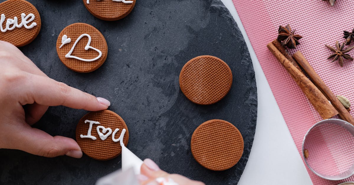 Multi-nozzle piping rig? - Crop woman decorating delicious cinnamon cookies with icing Multi-nozzle piping rig? - Crop woman decorating delicious cinnamon cookies with icing