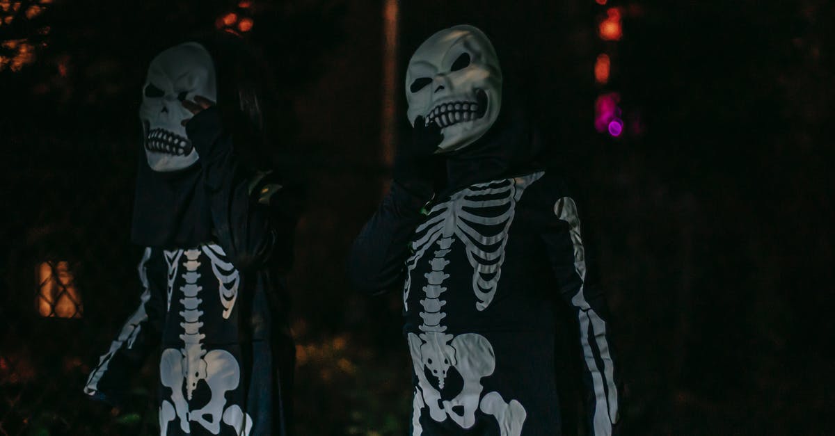 My seitan is horrible - Unrecognizable persons dressed in costumes of skeleton standing on dark street My seitan is horrible - Unrecognizable persons dressed in costumes of skeleton standing on dark street