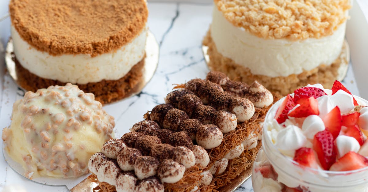 Name of alcohol made from sugar and honey - From above of set of tasty sweet deserts including tiramisu and round honey cakes near with glass jar of strawberry parfait served on white tray Name of alcohol made from sugar and honey - From above of set of tasty sweet deserts including tiramisu and round honey cakes near with glass jar of strawberry parfait served on white tray