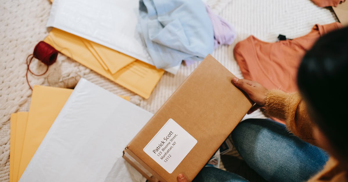 Name of this jar? - Top view of crop anonymous female with carton box of parcel checking address among envelopes Name of this jar? - Top view of crop anonymous female with carton box of parcel checking address among envelopes