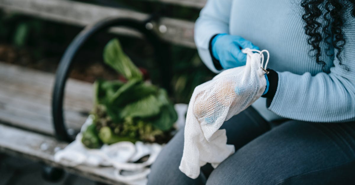 New green leaf vegetable in the family. What is it called? - Unrecognizable woman in gloves with eco friendly sack on street bench New green leaf vegetable in the family. What is it called? - Unrecognizable woman in gloves with eco friendly sack on street bench