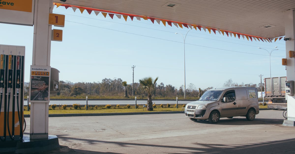 Nitrous oxide gas leak when charging ISI whipping cream dispenser - Car near gas station against cloudless sky Nitrous oxide gas leak when charging ISI whipping cream dispenser - Car near gas station against cloudless sky