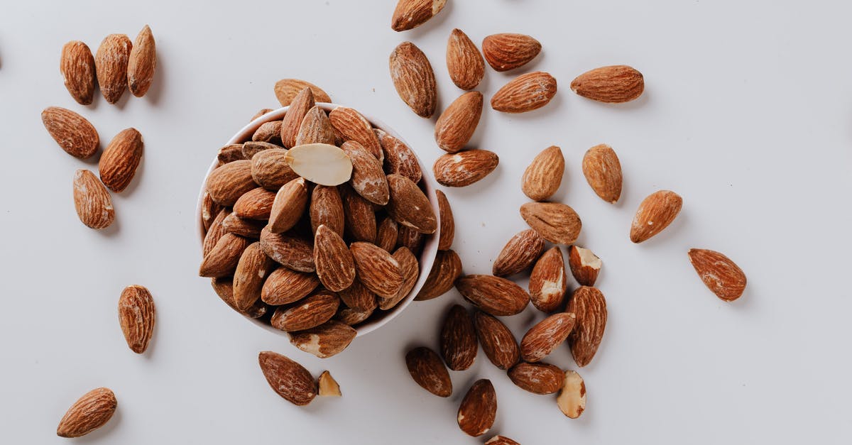 Nutrient composition of cheap cashews/nuts - Bowl filled with raw almond nuts on white background Nutrient composition of cheap cashews/nuts - Bowl filled with raw almond nuts on white background