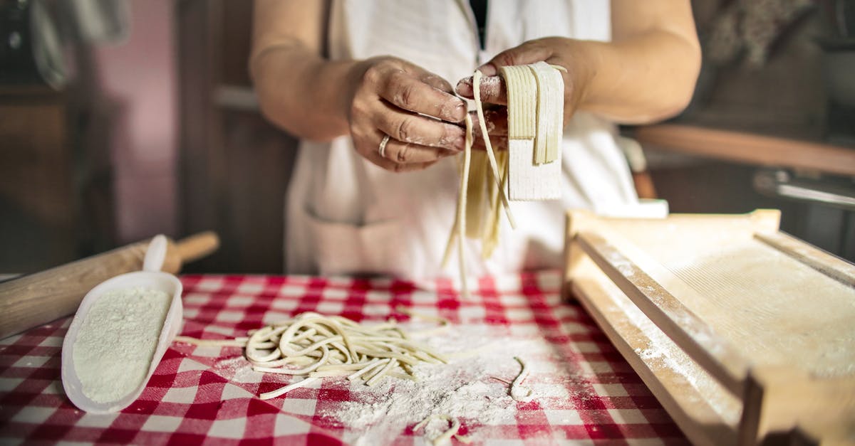 Oat Flour for pasta not rolling well? - Unrecognizable cook in uniform standing at table doing noodles from dough in kitchen at home Oat Flour for pasta not rolling well? - Unrecognizable cook in uniform standing at table doing noodles from dough in kitchen at home