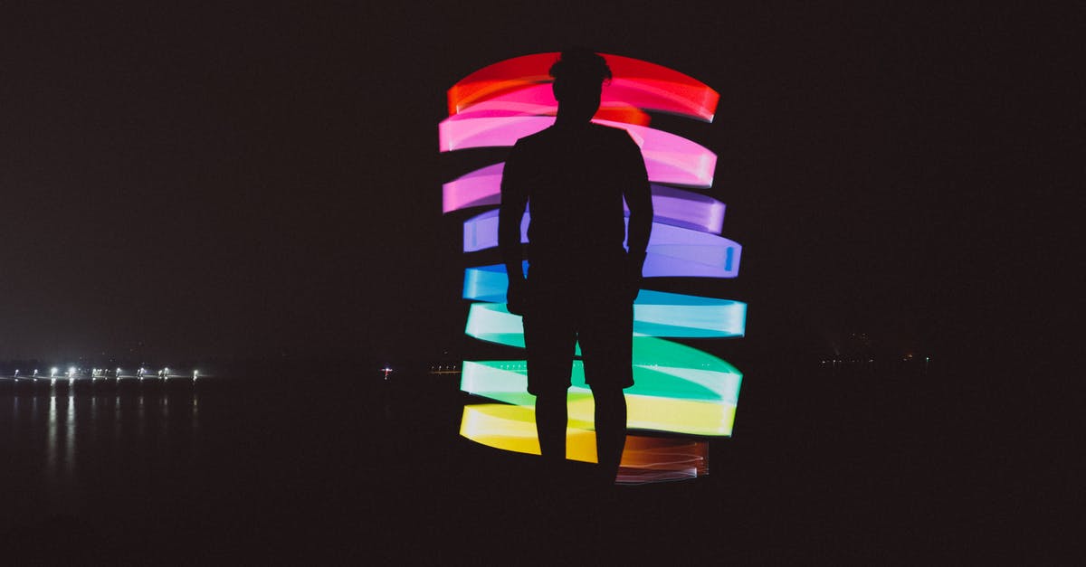 Of Vegetables that are spiralized how would you sort them from easy to difficult end of spectrum to Spiralize? - Full body of unrecognizable male standing near spiral illuminated multicolored lights on dark waterfront near sea in night time in city